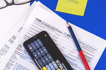 Accountant calculating taxes using calculator app on smartphone