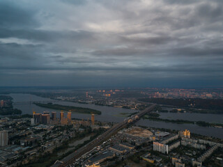 Obraz premium Aerial View of Kyiv, Ukraine – Dnipro River, Bridges and Sunset Above the Clouds