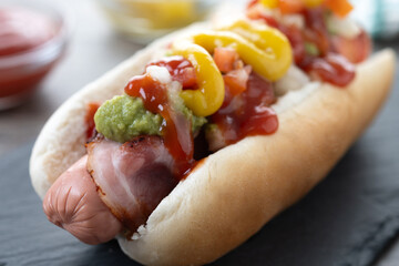 Sonoran hot dog. Traditional Mexican hot dog on wooden table. Close up