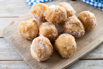 Traditional Carnival fritters or buñuelos de viento on wooen table