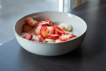 white ceramic bowl full of strawberry and banana slices close-up