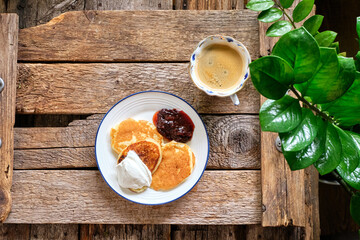 pancakes with cherry sauce. Wooden background, top view.	