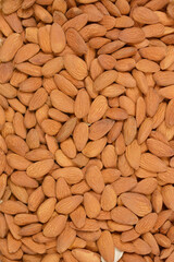 A close-up, top-down shot of a pile of raw almonds, showcasing their natural texture and color.