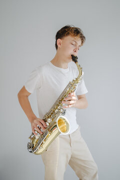 Young boy saxophonist plays music with emotion and focus