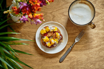 pancakes with mango and coconut. Wooden background, top view