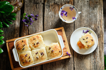 apricot buns with viola. Top view, wooden background. flower decoration