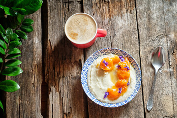 wheat semolina with apricot and viola. Top view, wooden background.