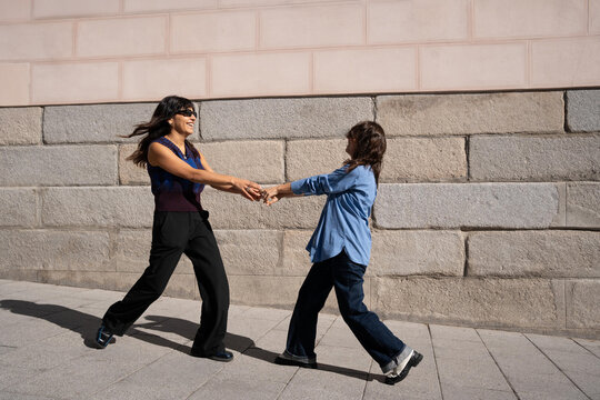 Joyful multiethnic lesbian couple celebrating love outdoors