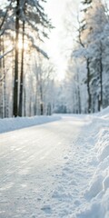 Fototapeta premium Snowy path through a winter forest with sunlight filtering through.