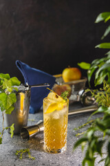 Refreshing apple cocktail garnished with fruit slices and thyme in elegant glass