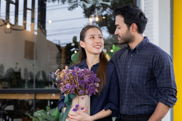 Small business startup, multicultural couple newlywed standing outside cafe, Asian woman and Indian or Hispanic man happy standing in front of new restaurant, entrepreneurship, teamwork, partnership