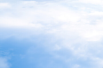 Expansive blue sky adorned with soft, fluffy clouds on a tranquil day