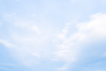 Soft clouds drift across a serene blue sky in the early afternoon light