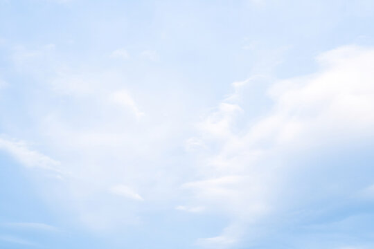 Soft clouds drift across a serene blue sky in the early afternoon light