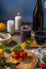 Colorful cheese with wine and lit candles creating romantic atmosphere