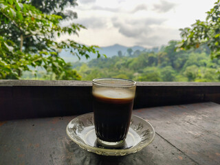A cup of coffee in the highlands, with beautiful and fresh mountain views in the background.