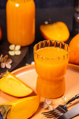 Glass of fresh persimmon juice with ripe persimmon slices
