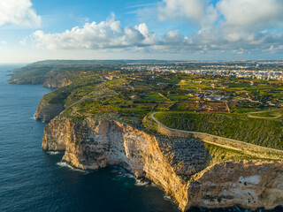 Drone view of green hills, countryside, cliifs. Mediterranean sea, blue sky. Malta island