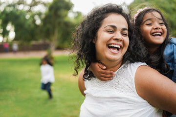 Happy indian mother having fun with her daughter outdoor - Family, mom day and love concept - Main...