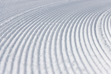 Close up of curved lines in white snow textured surface winter background