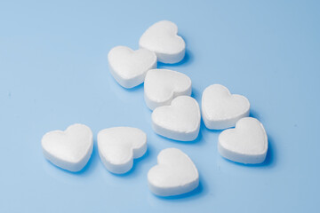The medical concept of diseases of the human cardiovascular system. A heart-shaped tablet on a blue background. Selective focus.