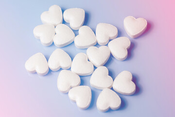 The medical concept of diseases of the human cardiovascular system. A heart-shaped tablet on a blue background. Selective focus.