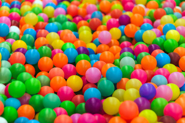 Background of many plastic colorful round balls in children's playroom for kids. Photography, childhood concept.