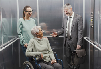 Happy people having a conversation in the elevator © stokkete
