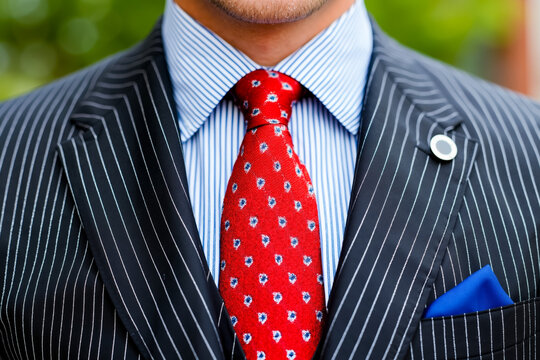 A man in a suit with a red tie and a blue pocket square