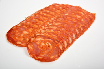 Several Sliced Spanish chorizo sausage isolated on a white  background. Pieces of the chorizo sausage