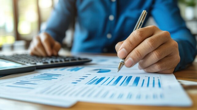 A person is writing on paper using a pen while calculating figures with a calculator, indicating a focus on tasks involving numbers and documentation.