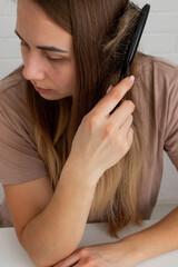 The woman holds a hair brush and vitamins from hair loss. Selective focus