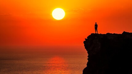 A lonely figure standing at the edge of a cliff, watching the last rays of the setting sun disappear