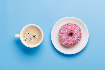 A vibrant donut with colorful toppings and a coffee cup