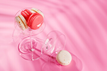 A delightful assortment of colorful macaroons arranged on a vibrant pink background