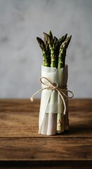 Bunch of fresh green asparagus tied with twine on rustic wooden table