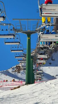 Ortisei, Italy - 02 02 2025: skiers and snowboarders at the ski lift car with the scenic view to Italian Dolomites 