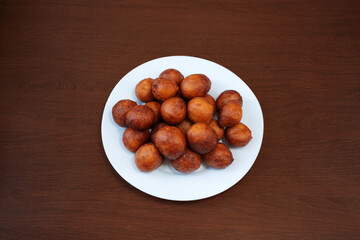 Fried donut holes beignets on wooden background from an African restaurant. International cuisine
