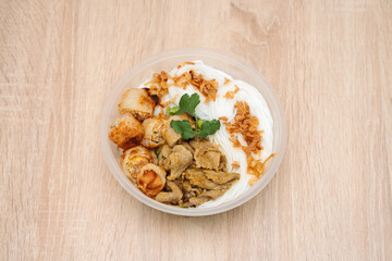 Bo Bun in plastic takeout container on wooden background. International cuisine