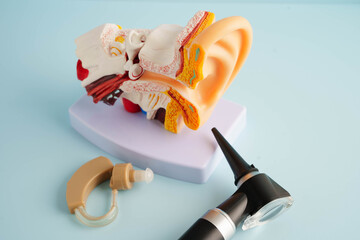 Otoscope with ear model for otolaryngologist or ENT physician doctor examining senior patient ear, hearing loss problem.