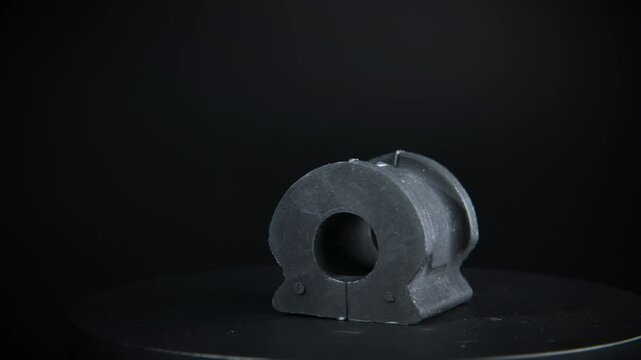 Rubber bushing of car suspension stabilizer, auto parts, rotating on black background