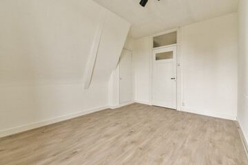 A clean and minimalist room featuring white walls and a wooden floor, showcasing simplicity and tranquility in interior design.