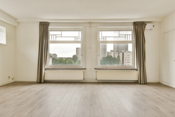 Fototapeta premium Bright and airy room featuring large windows that allow natural light, paired with minimalistic decor and wooden flooring, perfect for modern living.