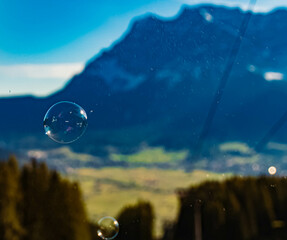 Alpine summer view with soap bubbles in front of Mount Zugspitze, Top of Germany, Garmisch-Partenkirchen, Bavaria, Germany