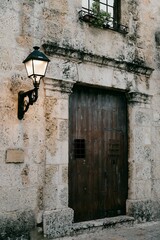 Rustic stone wall with a vintage lamp and door.
