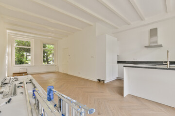 Bright and spacious kitchen featuring modern fixtures, wooden flooring, and large windows that let in natural light, creating an inviting atmosphere.