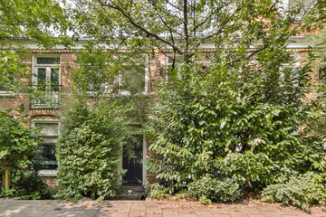 This image showcases a charming brick house enveloped in vibrant greenery, exemplifying a harmonious blend of architecture and nature.