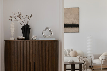 Stylish living room with neutral tones, a sculptural wooden cabinet, abstract wall art, and modern decorative accents.