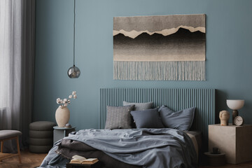 Stylish bedroom with a headboard in soft blue, a decorative woven tapestry, and an inviting bed...