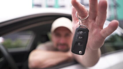 Male hand gives a car keys to male hand in the car dealership close up. - Powered by Adobe